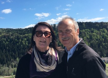 Brenda and David Miley pose for a smile in front of a picturesque scene of trees