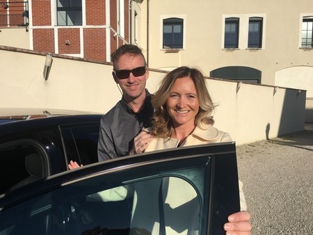 Stephen and Lilly Lenehan pose behind an open car door, both smiling